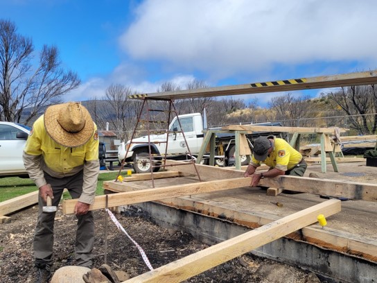 Workers rebuild a hut