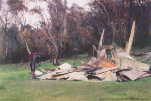 Photo Colin Brown. John Purves examining Boobee Hut burnt after the 2003 fires