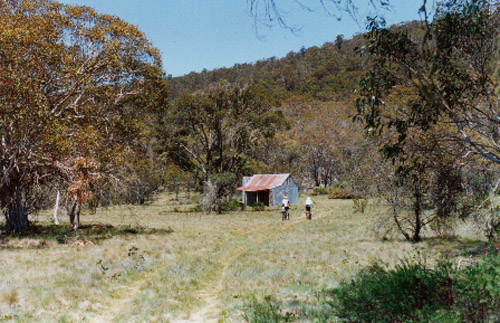 Photo of two cyclists on a foot track approaching Bill Jones Hut