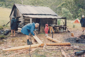 Vickerys Hut Workparty, Leonie Hamilton supervising the trimming of logs, 1987.
